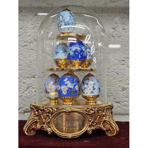 324 - From the house of Faberge, Sapphire Garden a group of miniature Eggs covered by a dome.
 H 13 cm app... 