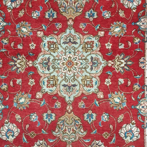 58 - A Persian Tabriz Red ground Rug with a rich Red ground and an all over floral pattern. 180 x 125 cm ... 