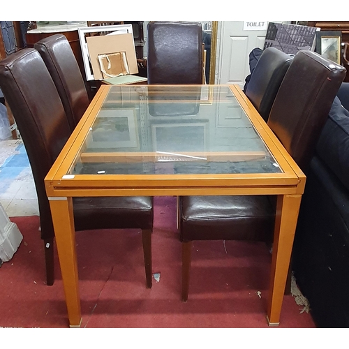 928 - A modern glass topped extendable Kitchen Table along with a set of five leather upholstered chairs.
... 