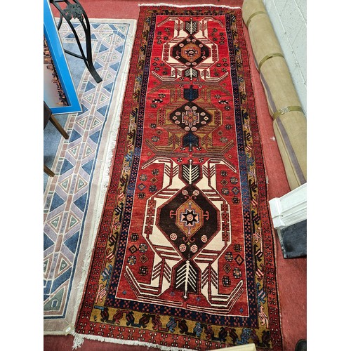 917 - A good Persian red ground Runner with multi borders and unique central Aztec design. 327 x 120 cm ap... 