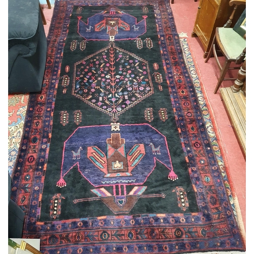 937 - A Persian blue ground Rug with multi borders and unique central medallion design. 305 x 138 cm appro... 