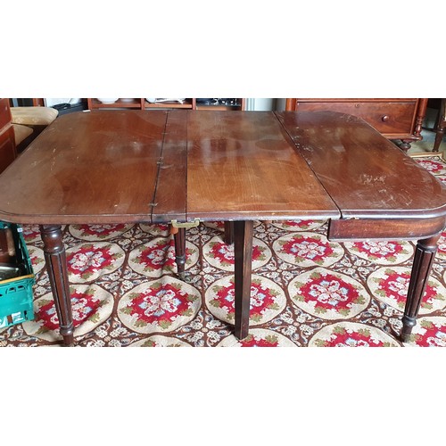 186 - An early 19th Century Mahogany dining Table with central scissor movement rails on turned reeded sup... 