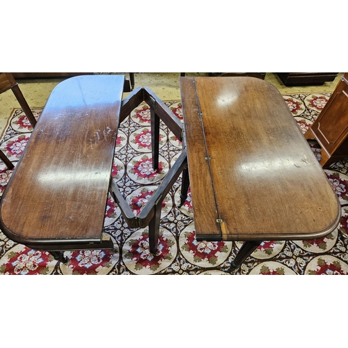 186 - An early 19th Century Mahogany dining Table with central scissor movement rails on turned reeded sup... 