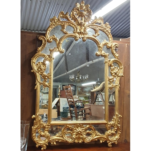 206 - A good reproduction Gilt overmantel Mirror with a highly ornate outline. 144 x 97 cm approx.