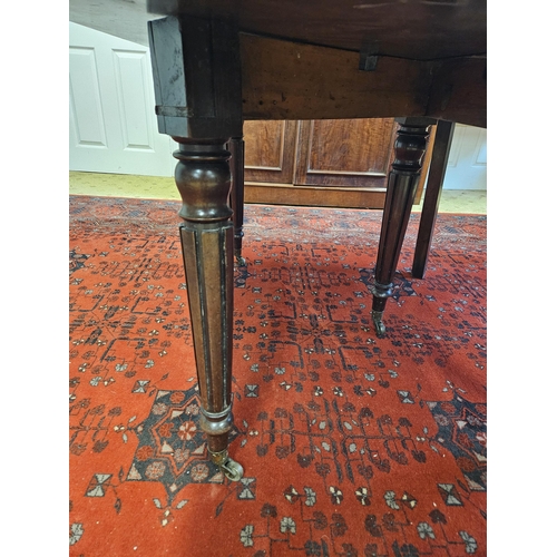 186 - An early 19th Century Mahogany dining Table with central scissor movement rails on turned reeded sup... 