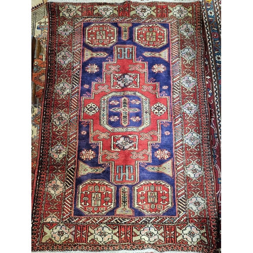 221 - A good Red ground Persian Rug with central Aztec central medallion design. 175 x 115 cm approx.