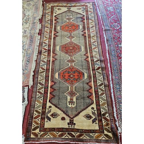 222 - A good Red and Beige ground Persian Runner with Aztec central medallion design. 316 x 137 cm approx.