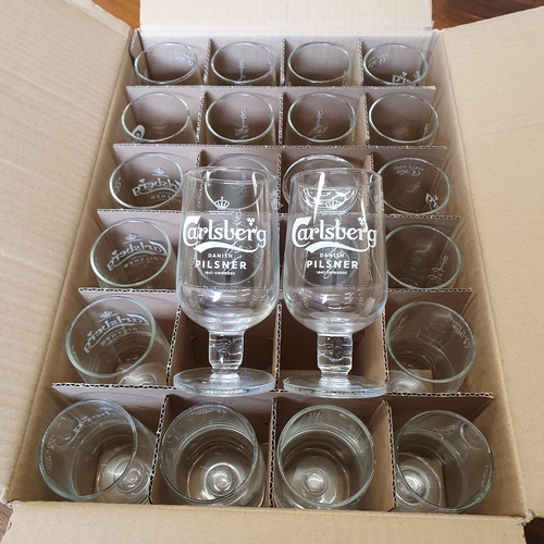 713 - A quantity of Guinness Glasses along with a quantity of Carlsberg branded glasses.