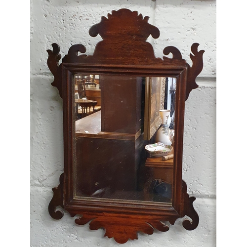 98 - An early 20th Century Mahogany Mirror with highly carved outline. 43 x 29 cm approx.