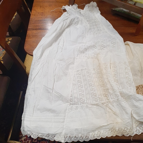 52 - A vintage Shawl, Christening Dress and and a set of four rush table Matts.