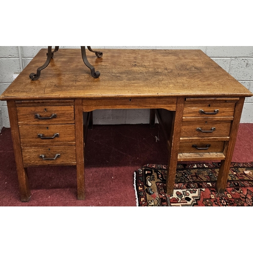 196 - A 20th Century Oak kneehole clerks Desk with triple bank drawers and brushing slide. 137 x 76 x H 77... 