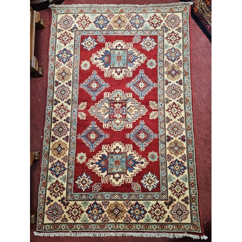 598 - A really good red ground Persian Rug with blue and beige borders. 173 x 114 cm approx.