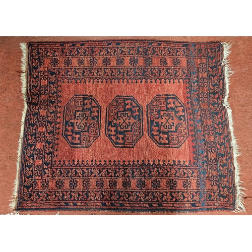 65 - A red ground Rug with repeating central medallion design and multi borders. 99 x 118 cm approx.