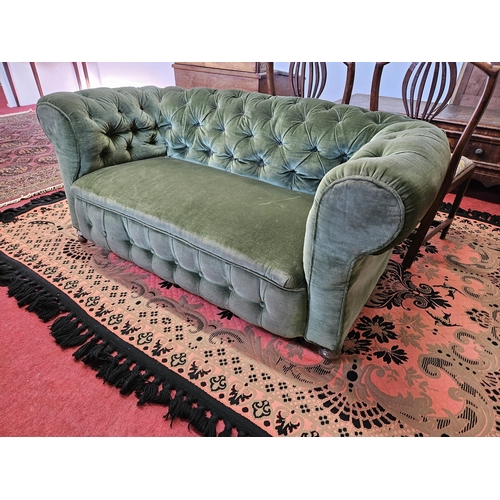 99 - A good 19th Century deep buttoned Chesterfield two seater settee with drop arm on turned supports. W... 