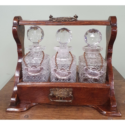 689 - An early 20th Century Oak cased Tantalus with triple decanters.