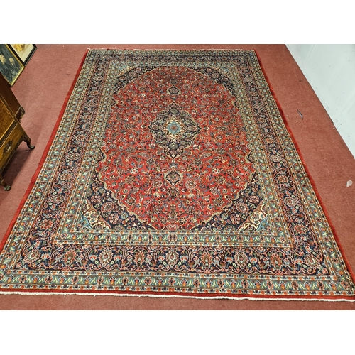 768 - A Red ground Persian Kashan Carpet with a multi coloured floral pattern and a central medallion Kash... 