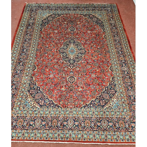 768 - A Red ground Persian Kashan Carpet with a multi coloured floral pattern and a central medallion Kash... 