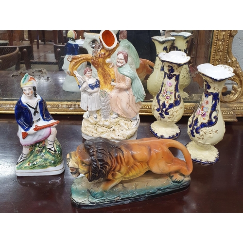 86 - Two 19th Century Staffordshire Figures along with a pair of bud vases and a pottery figure of a lion... 