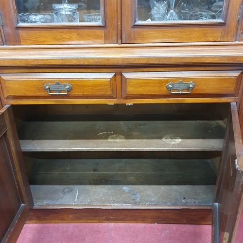 151 - A Victorian Walnut two door Bookcase with highly carved panelled doors with a glazed upper and twin ... 