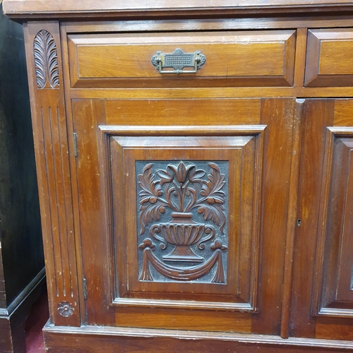 151 - A Victorian Walnut two door Bookcase with highly carved panelled doors with a glazed upper and twin ... 