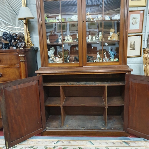 251 - Of Fantastic quality. An early 19th Century Mahogany two door Bookcase with reeded column supports a... 