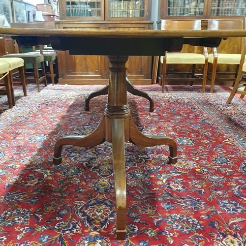 303 - An early 19th Century two Pillar Dining Table on tripod supports with twin leaves.
H 74 x W 233 x D ... 