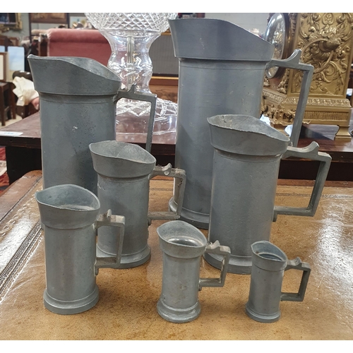 701 - A good graduated set of Pewter Measures with stamped letters. Tallest H 21 cm approx.