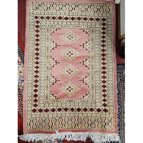 733 - A Pink ground Rug with repeating central medallion design. L 84 x W 34 cm approx.