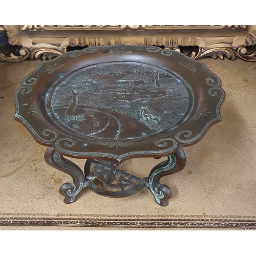 737 - A good Oriental Bronze Plate on stand with a highly carved and moulded outline (stand needs repair).... 