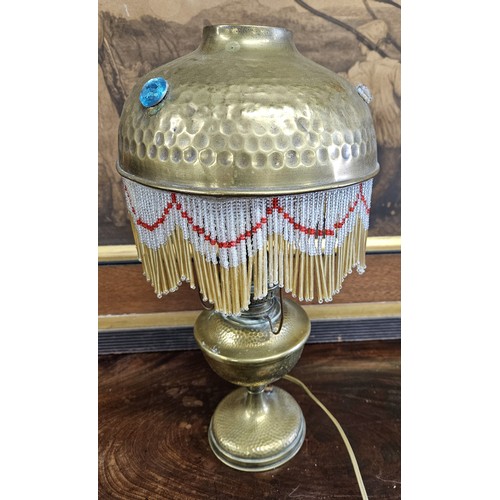 749 - An unusual early 20th Century converted Oil Lamp with tasseled outline. H 37 cm approx.