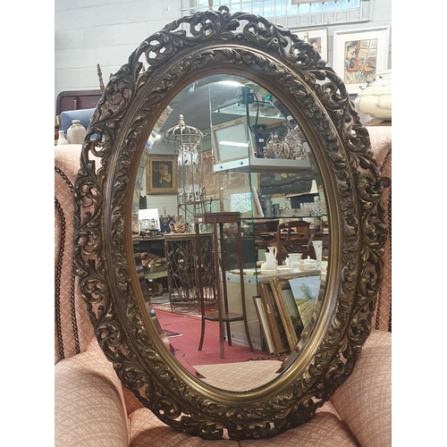 822 - A late 19th Century Timber and Plaster gilt oval Mirror with a highly carved outline.
H 99 x W 66 cm... 