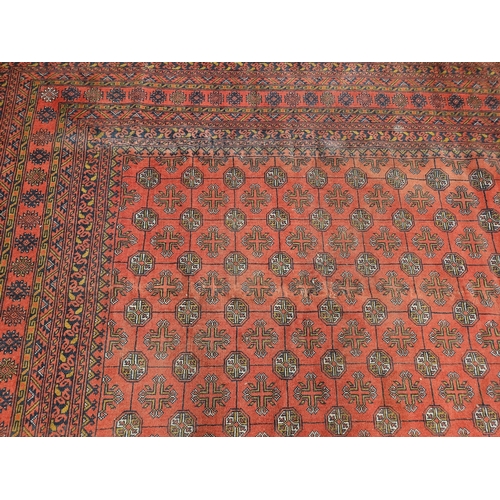 7 - A washed Red ground and woven Turkman Carpet with a traditional all over design.  337 x 245 cm appro... 