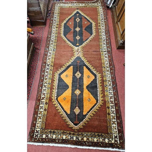 15 - A Terracotta ground hand woven Persian Qashqai nomadic Runner with a double medallion design, 275 x ... 