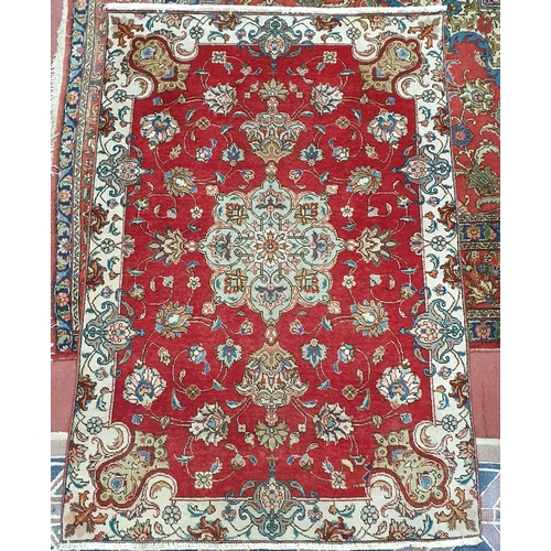 16 - A Persian Tabriz Red ground Rug with a rich Red ground and an all over floral pattern. 180 x 125 cm ... 