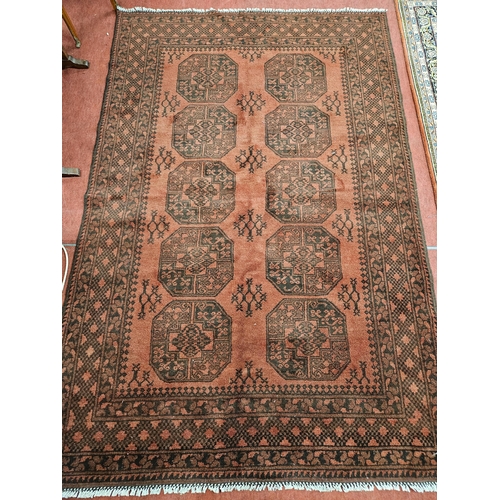 30 - A washed Red ground Afghan double knotted Carpet with traditional Bakarah repeating central medallio... 