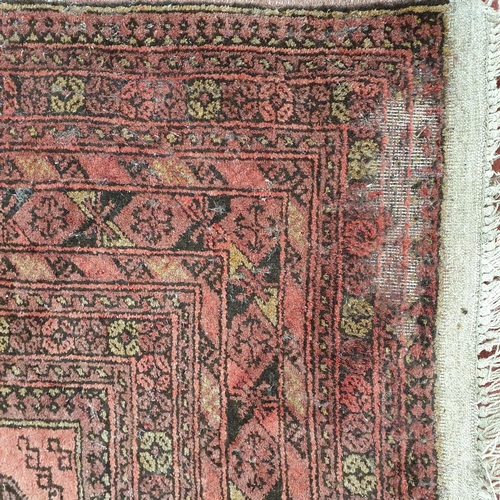 52 - A red ground Rug with repeating decoration. (some faults) .
 297 x 205 cm approx.