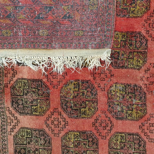 52 - A red ground Rug with repeating decoration. (some faults) .
 297 x 205 cm approx.