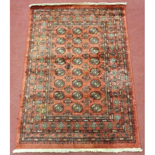 64 - A Red ground Rug with repeating medallion design, 140 x 98 cm approx.