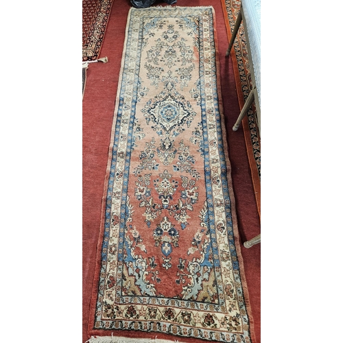 85 - A good hand knotted Red ground Runner with multi borders and central medallion design, 285 x 96 cms ... 