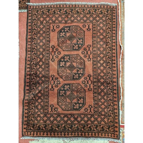 87 - A Red Rug with repeating central medallion design. 98 x 141 cm approx.