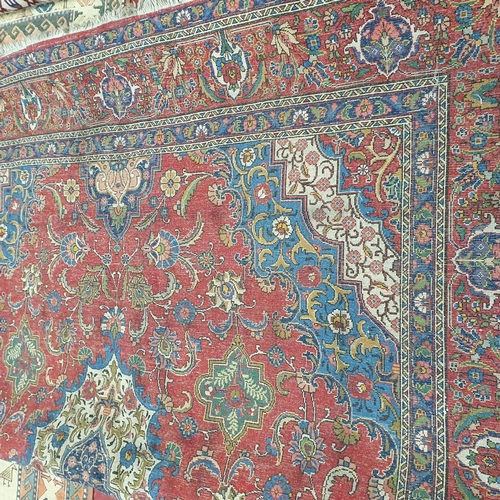 44 - A large Persian Red ground Carpet with a unique central medallion design 400 x 300 cm approx.