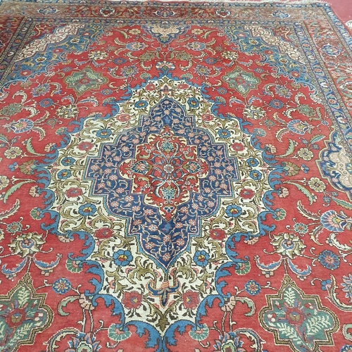 44 - A large Persian Red ground Carpet with a unique central medallion design 400 x 300 cm approx.