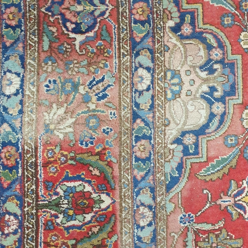 44 - A large Persian Red ground Carpet with a unique central medallion design 400 x 300 cm approx.