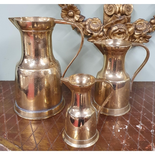 189 - A 19th Century graduated set of three Brass Jugs of superb quality.