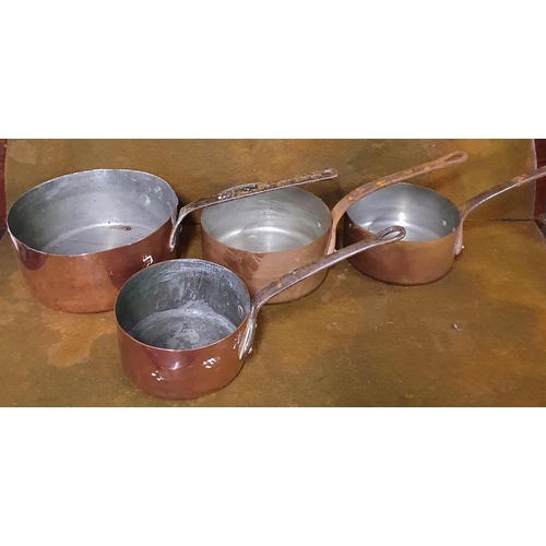 235 - A heavy graduated set of Copper Saucepans with cast iron handles. 
Smallest H 9 x D 15 and Largest H... 