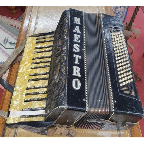 274 - A vintage cased Maestro accordion along with sheet music.