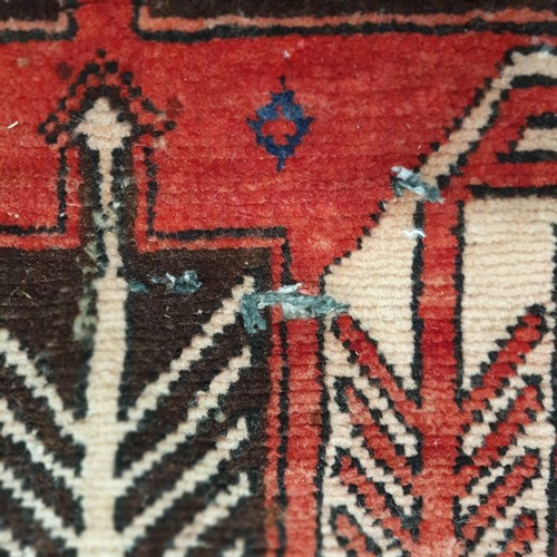 45 - A good Persian red ground Runner with multi borders and unique central Aztec design. 327 x 120 cm ap... 