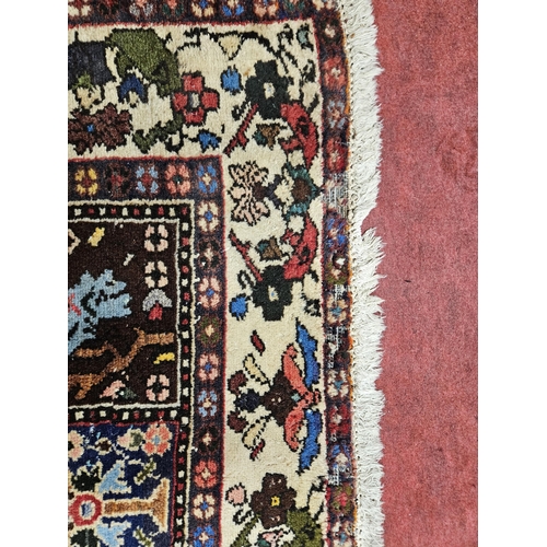 174 - A Persian cream ground Rug with central rectangular panel design and multi borders. Some slight faul... 