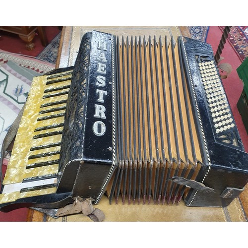 274 - A vintage cased Maestro accordion along with sheet music.