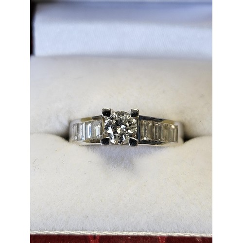 422 - An 18ct White Gold and Diamond Ring with a single round brilliant cut Diamond supported by four bagu... 